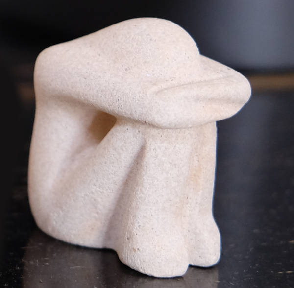 Bid einer Figur, die in sich zusammenkauert
